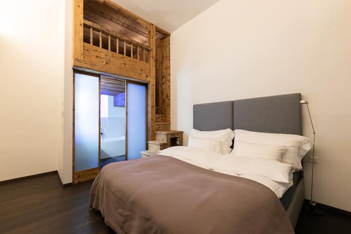 Angelus — bedroom beneath the wood-beamed mezzanine