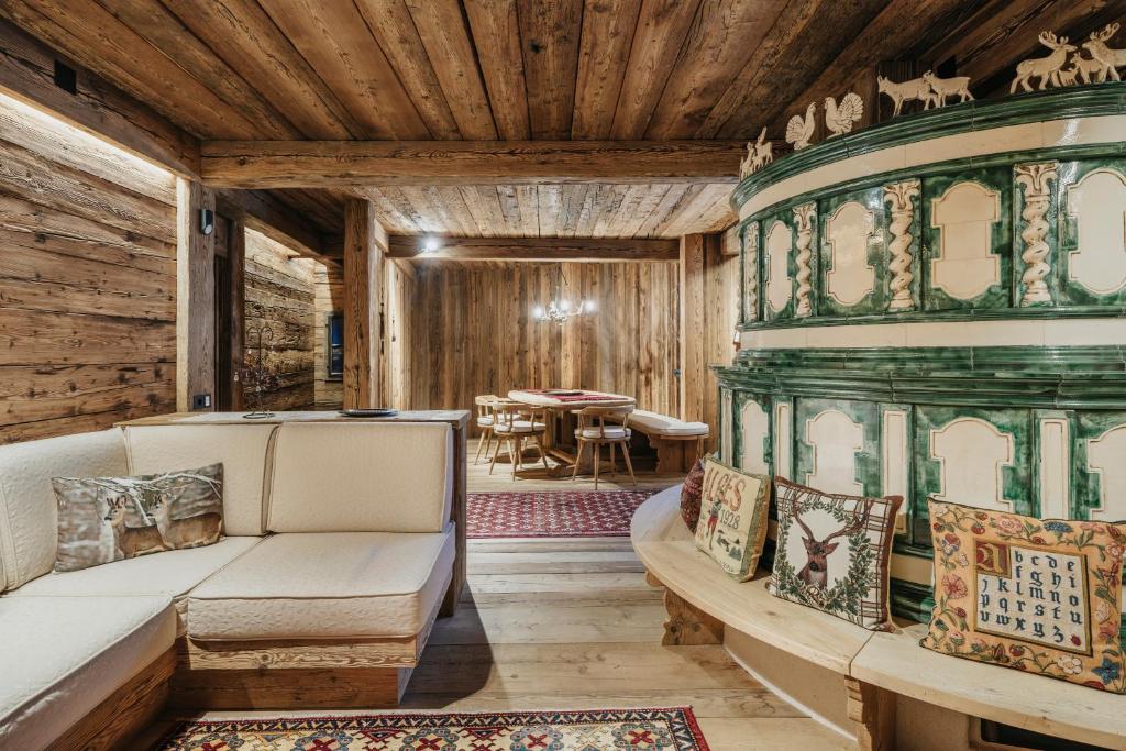 Casa Aurea, Cortina d'Ampezzo — sitting room with sofa beside the majolica stove