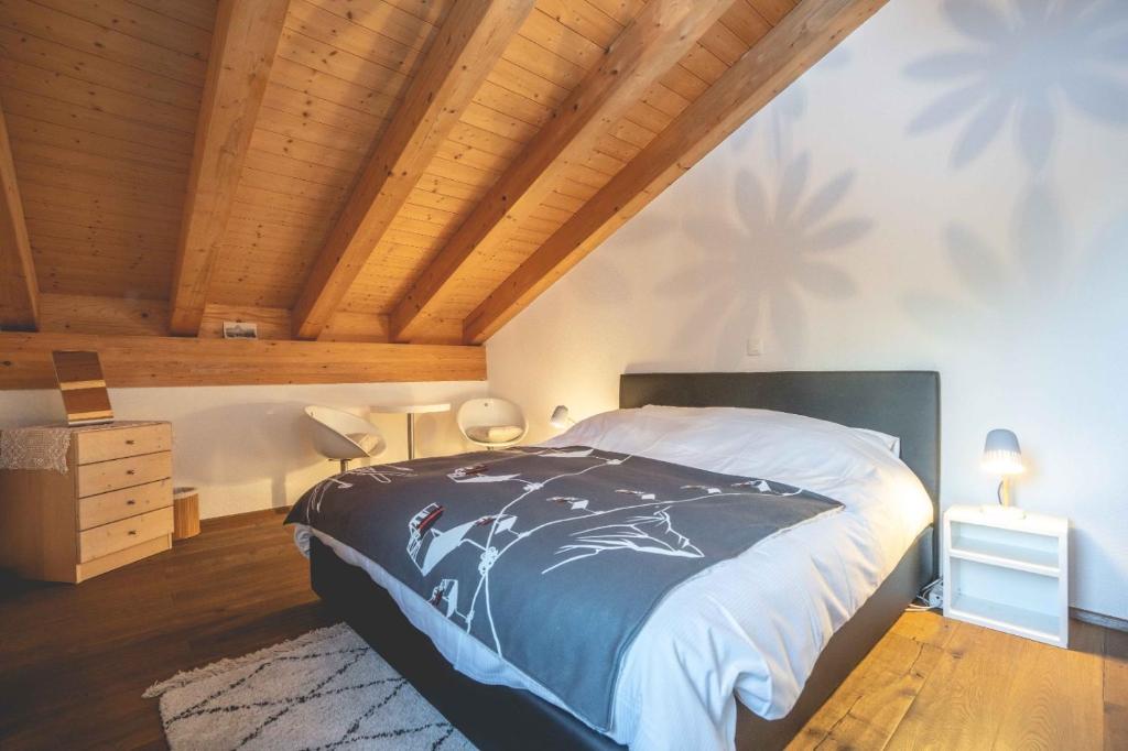 Chalet Talisman, Zermatt — attic bedroom under wood-beamed ceiling